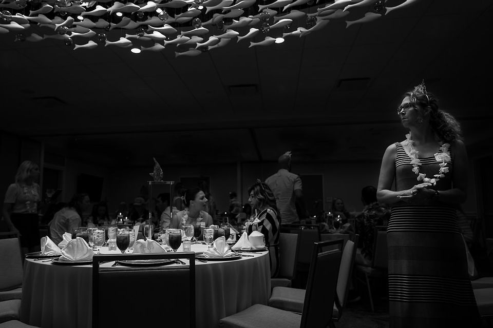 highlight on the fish decor in the ceiling, the table under and a woman on the right