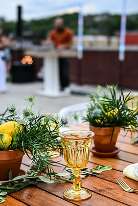 Detail shot of yellow glassware and floral arrangement on a rooftop wedding table in Kansas City