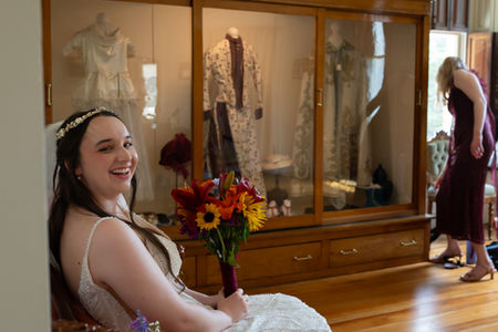 Isabel smiling with her maid of honor in the background