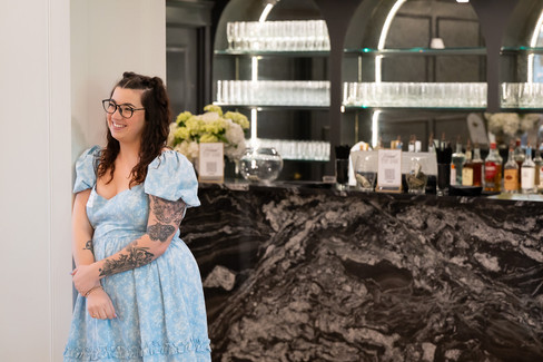 Melrose Abbey staff member laughing in front of the venue's bar.