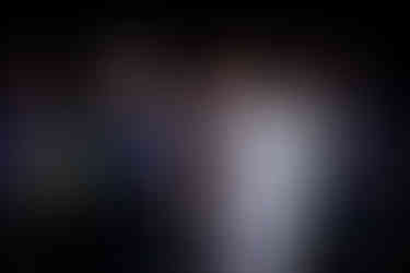 Jacqueline and Shonda at the altar holding hands and looking at each other, with the pastor and two bridesmaids in the background.