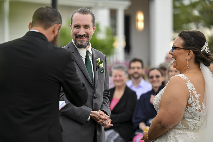 Groom smiling after putting the ring on bride during outside ceremony of a wedding at Lone Summit Ranch.