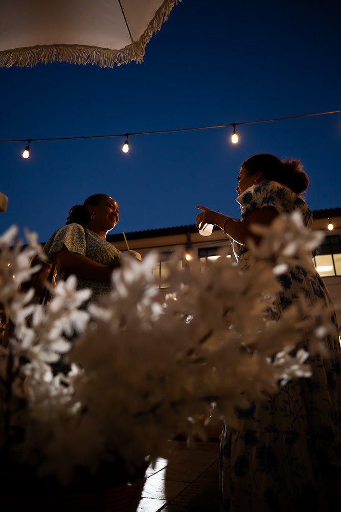 silhouette of 2 vendors discussing under the night sky in the patio of Unity Village