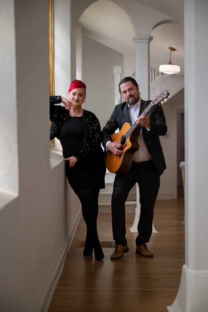 Strawberry Jam music group posing by the window inside Melrose Abbey chapel.