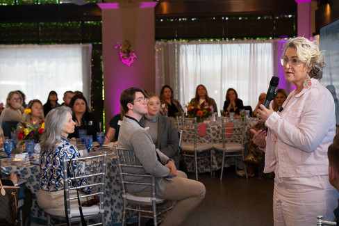 Paige White delivering a talk with attendees listening in background