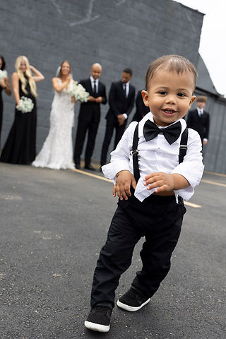 Son of bride and groom running away during pictures before wedding