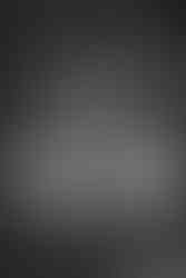 Black and white photo inside Melrose Abbey chapel with large window below and bride and groom on upper level.