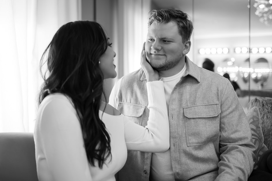 Man looking lovingly at fiance while she puts her hand on his face at Warren Place Venue