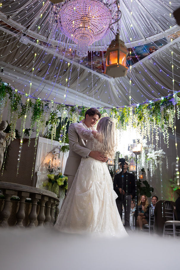 A young married couple is having their first dance as a married couple in a dreamy, smoky ambiance at the Secret Garden Venue in Independence.