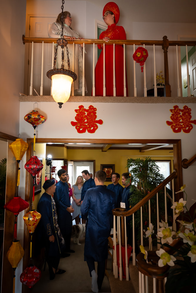 Bride waiting on the second floor while groom and groomsmen gather below