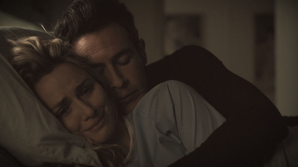 Couple in a hospital bed; woman looks upset, man comforts her, eyes closed. Dim lighting; sombre mood. Pillow and blue shirt visible.
the shot is from S5 Ep23 in the final few minutes. with John and Shantel