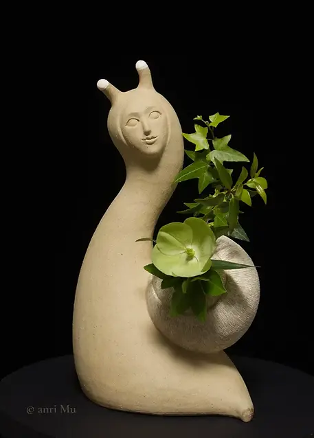 anriMu_sculpture_Departing Snai_A full frontal view of someone arranging flowers.