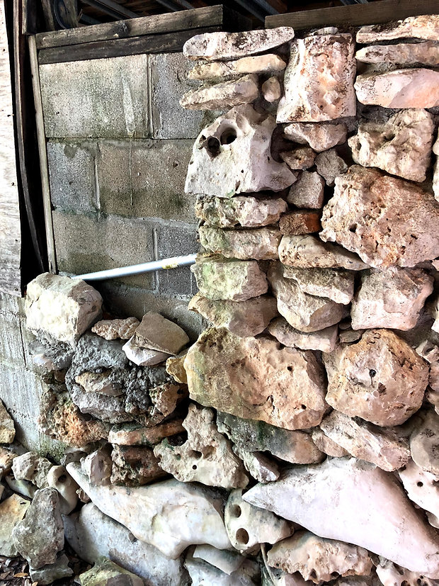 Rock wall built by dementia. The left side is haphazard with goopy mortar but the right is beautiful with honeycomb rocks stacked in aesthetic order with rocks hand picked from Hudson Bend near Lake Travis (Austin, TX).