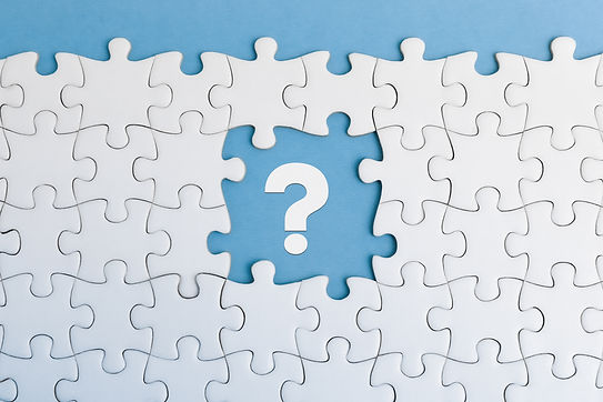 An incomplete jigsaw puzzle with a distinct absence of a white question mark piece on blue