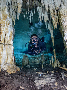 scuba diver diving through underwater rock formations 