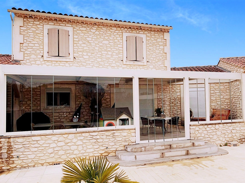 Photo de la pergola bioclimatique sur-mesure avec vitrage Sol Design Solembra sur maison en pierre rénovée de nos clients à Arles, Bouches-du-Rhône, dans le Sud de la France, comme nouvelle pièce de vie en toutes saisons - vue de face