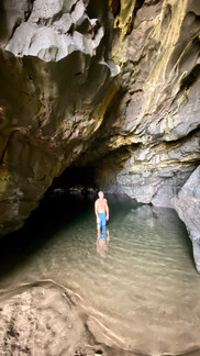 Person standing in a serene cave pool