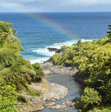 Aerial view of Oheo Gulch pools (aka Seven Sacred Pools) by the ocean with a half rainbow