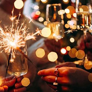 Friends celebrating New Year’s Eve with sparklers and champagne in a festive setting, capturing the Western tradition of countdown parties