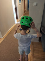 Chłopiec zakłada kask rowerowy