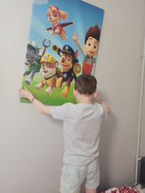 chłopiec wiesza plakat na ścianie