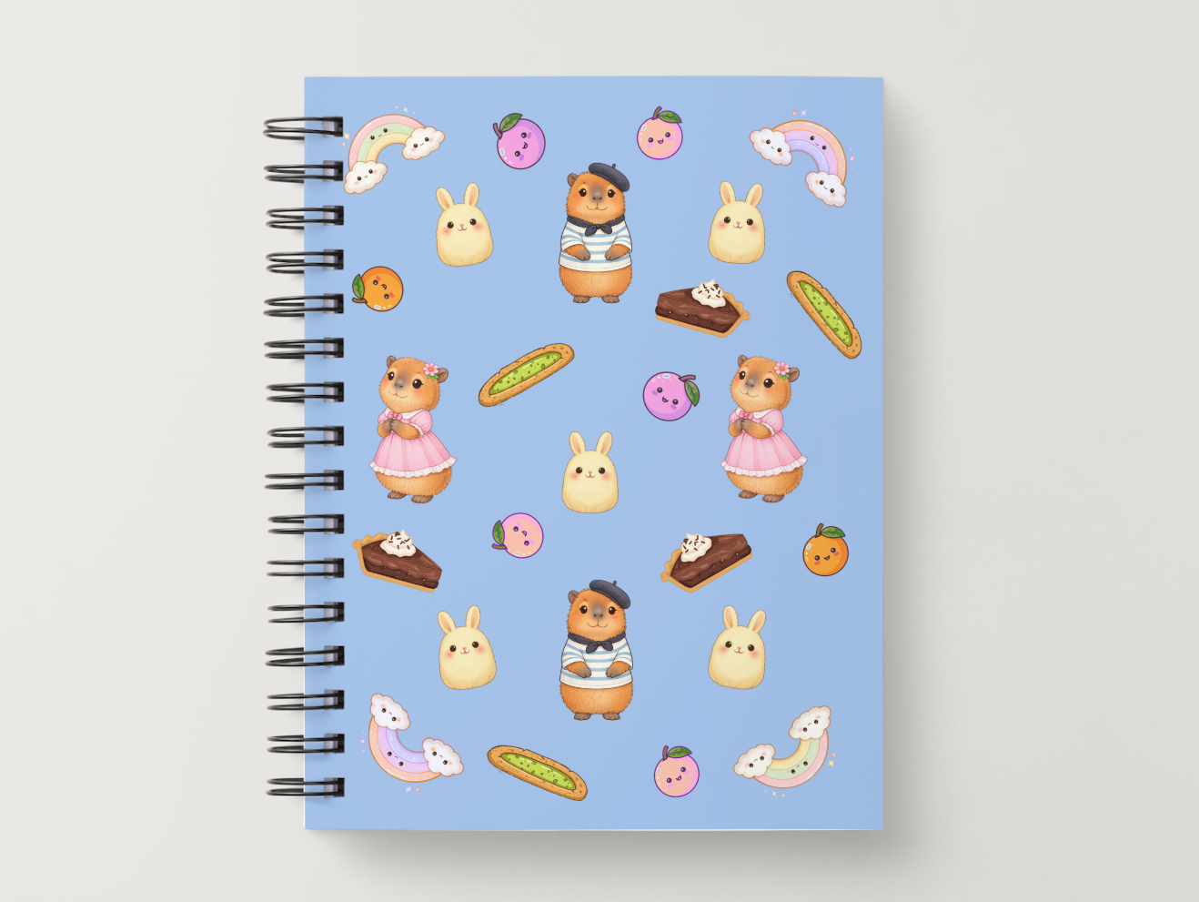 cartoon style capybaras wearing beret and bunny with oranges and rainbow and bread scattered on the cover of notebook.