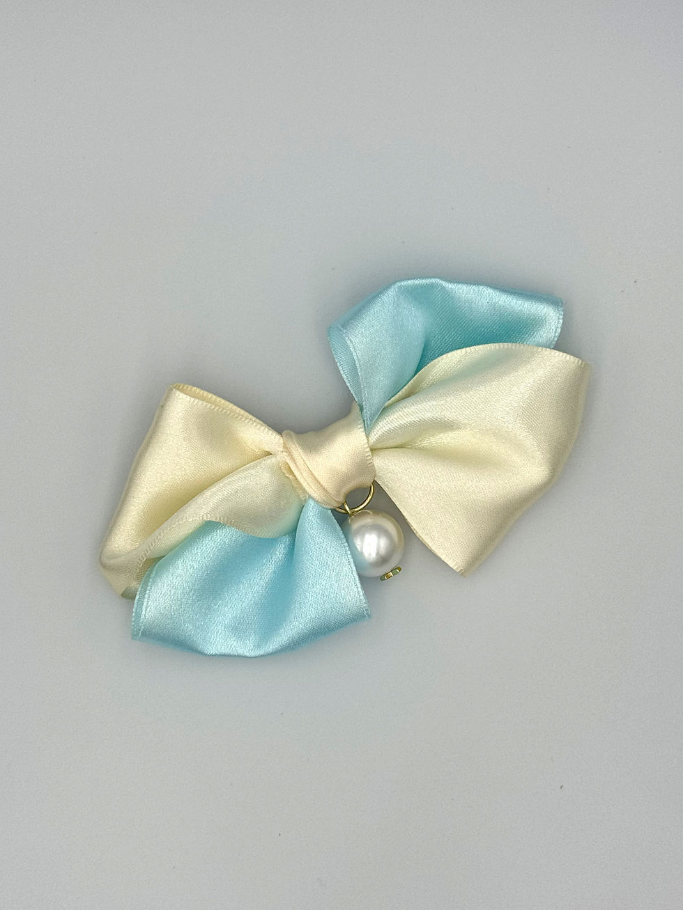 Thumbnail: Yellow and light blue bow pin with white pearl.