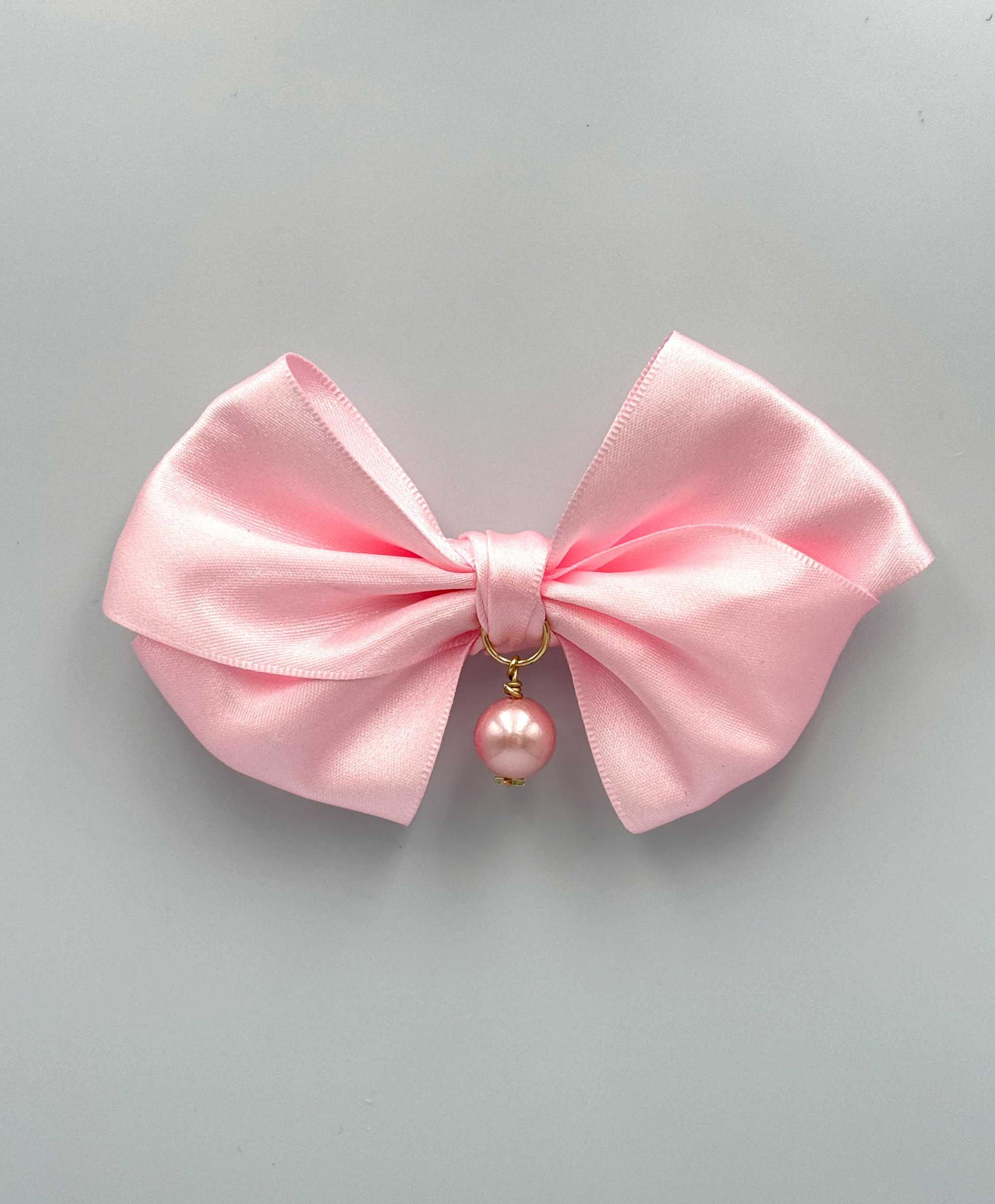 Pink satin bow pin with pink pearl.