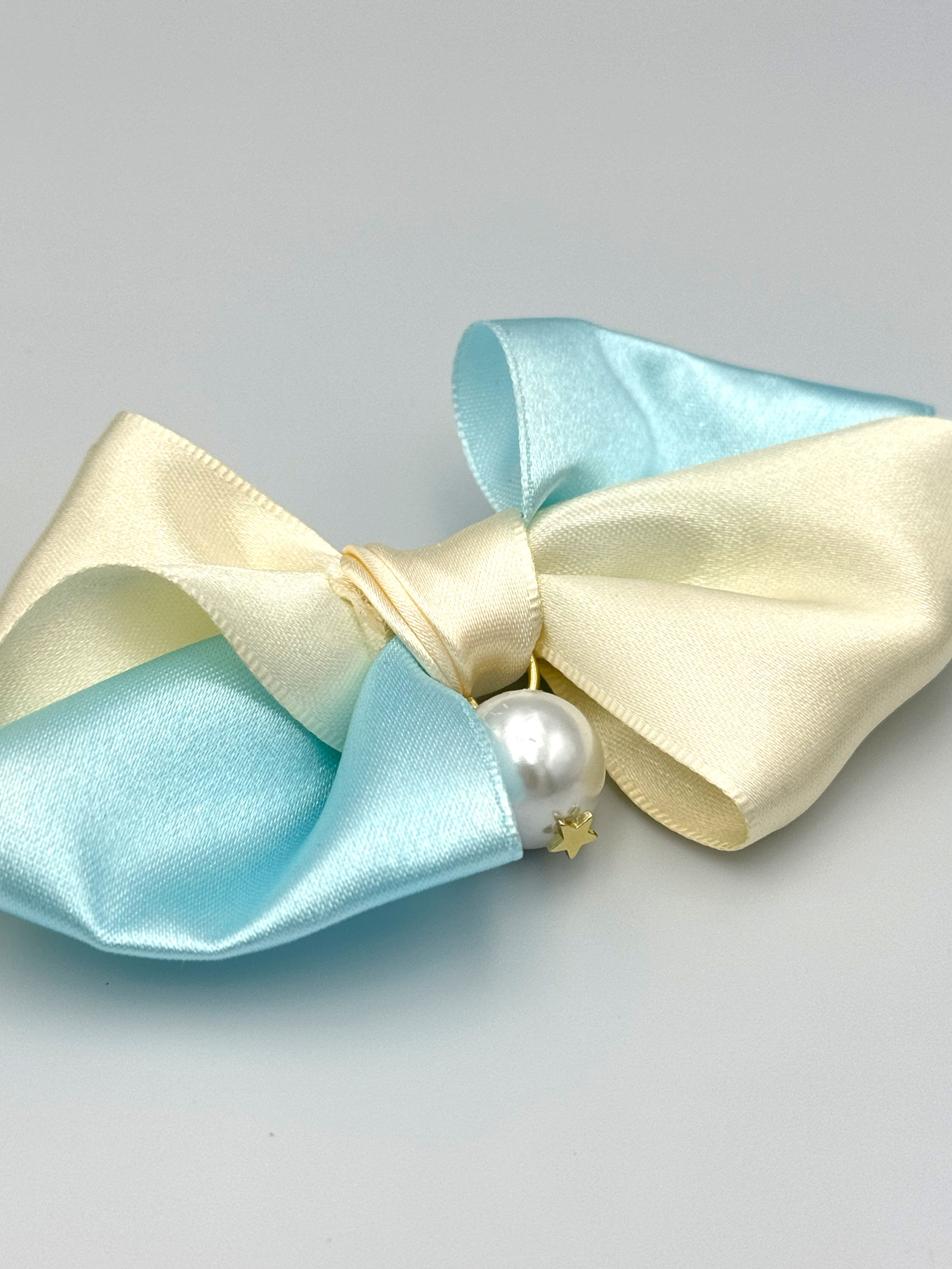 Satin bow, light blue and cream, with a pearl.