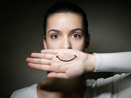Mulher com um falso sorriso por causa de uma relacionamento abusivo