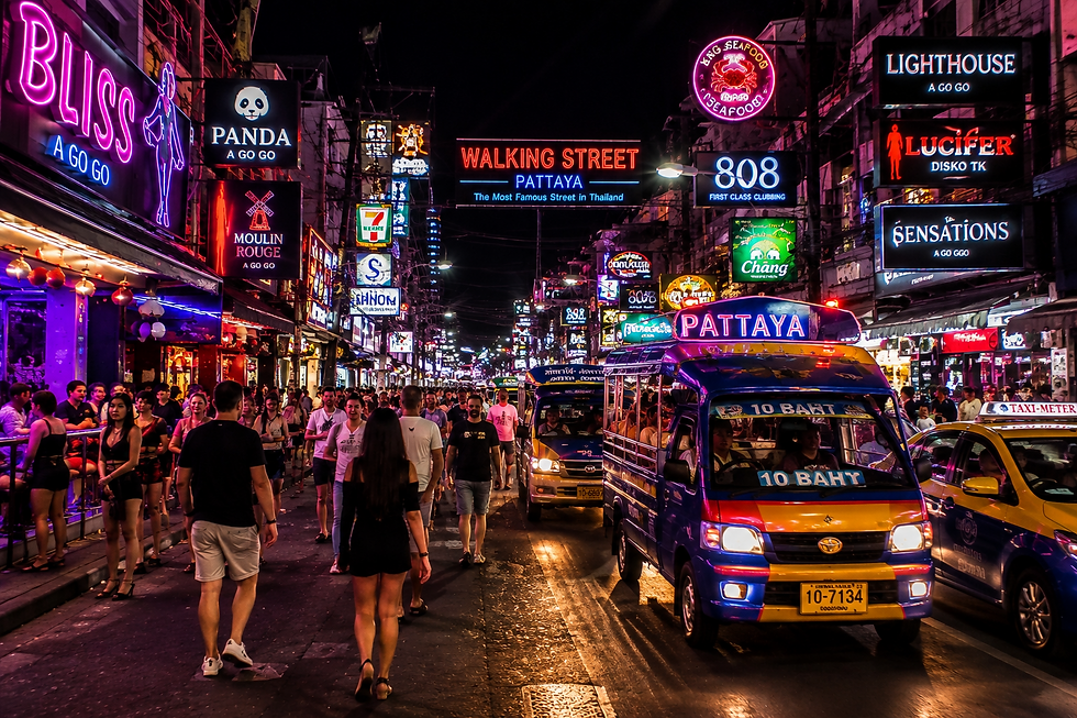 Pattaya nightlife with neon bars, restaurants, taxis, and pedestrians