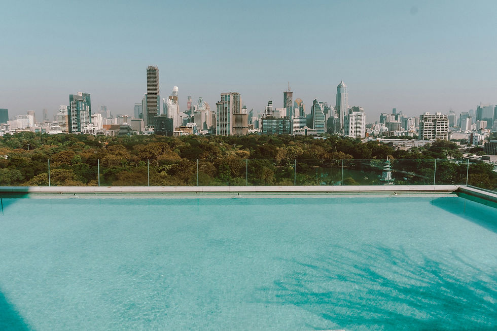 Rooftop infinity pool above a Thai city skyline