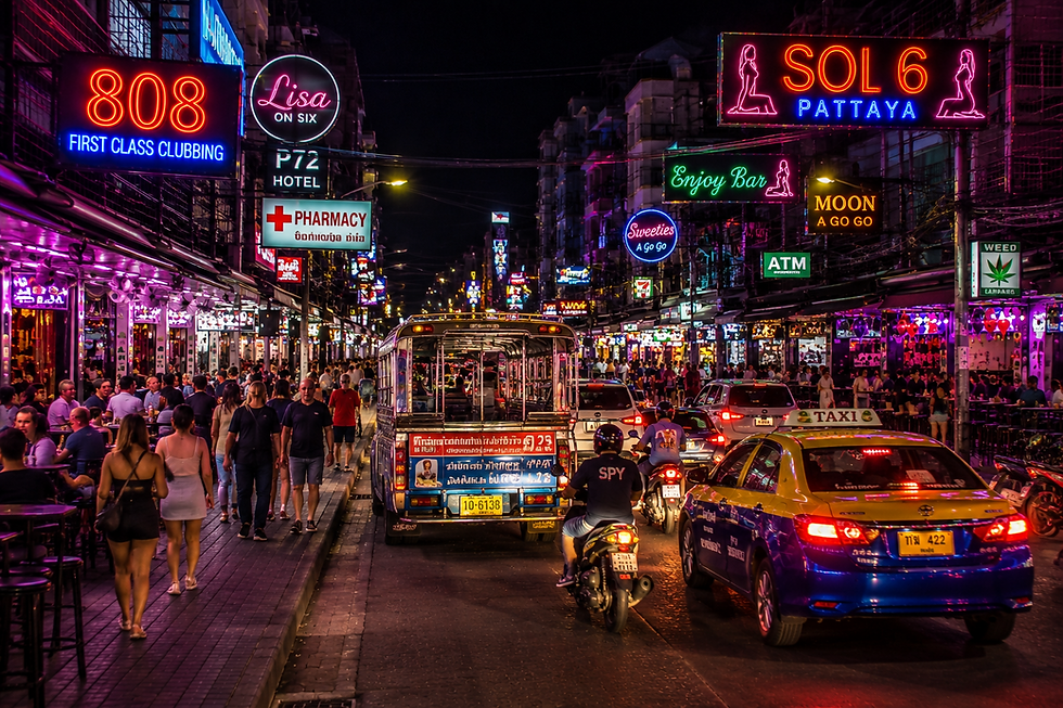 Soi 6 Pattaya transportation with taxis, motorcycles, baht buses, and pedestrians at night