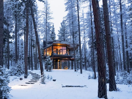 a modern tree house cabin in the snow