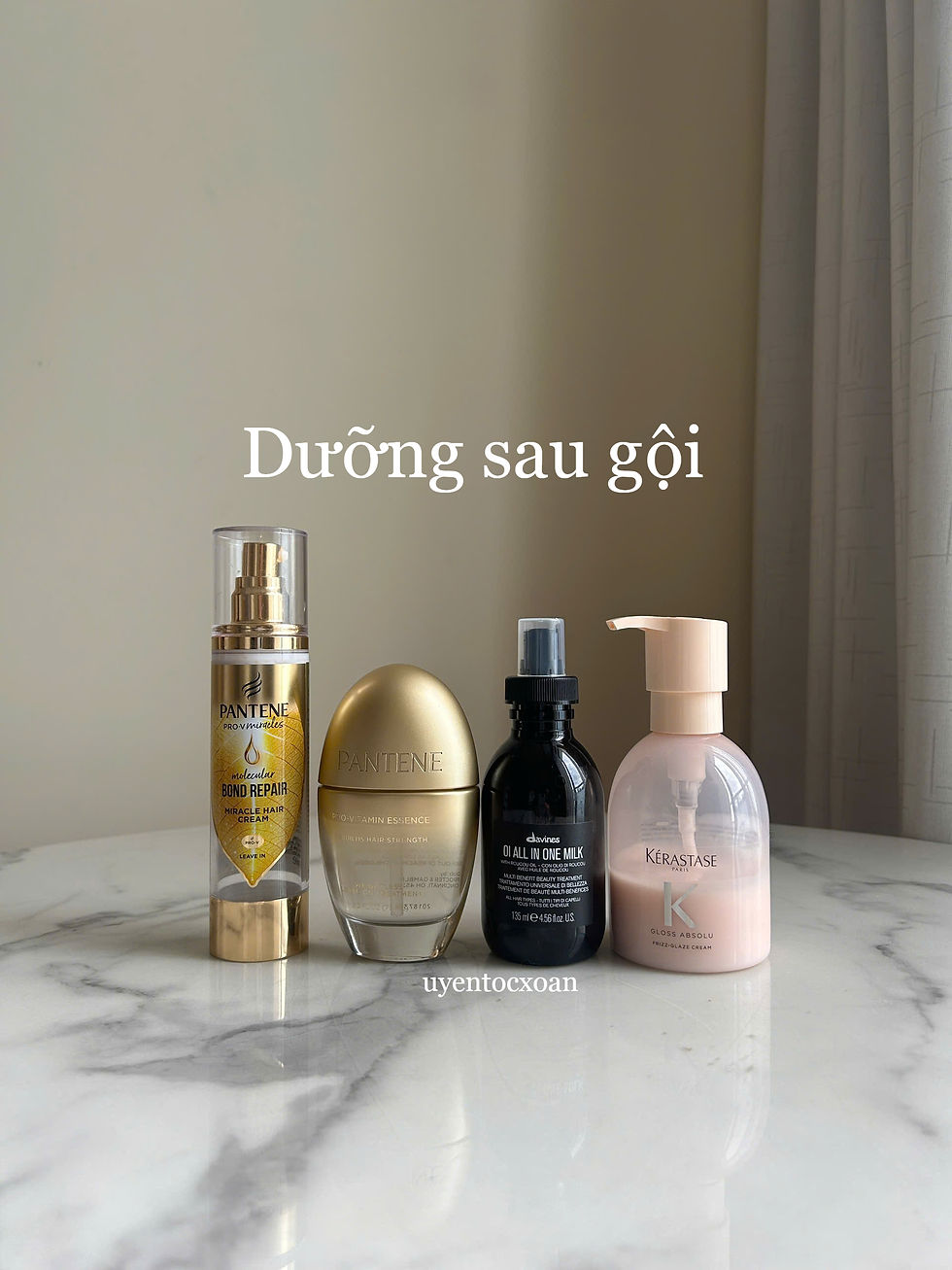 Four hair care bottles on a marble surface, labeled Dưỡng sau gội, Pantene, Davines, and Kérastase, against a beige wall.