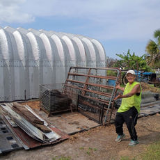 Alex helping organize building materials at Creature Safe Place, dedicated volunteer at wildlife sanctuary