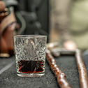 Cut crystal glass with dark liquid on a table