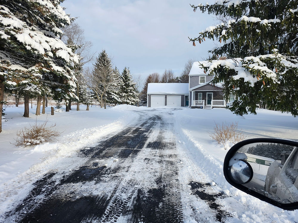 Clean snow plowed city driveway in Niagara Falls NY after winter storm by Berner Property Services truck