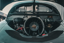 "Der Tatra 600 Tatraplan, ein stromlinienförmiger Oldtimer aus den 1940er Jahren, bekannt für sein innovatives Design, aerodynamische Karosserie und luftgekühlten Vierzylinder-Boxermotor, ausgestellt im Manro Classic Museum."