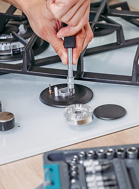 Technician adjusting a stove's temperature settings