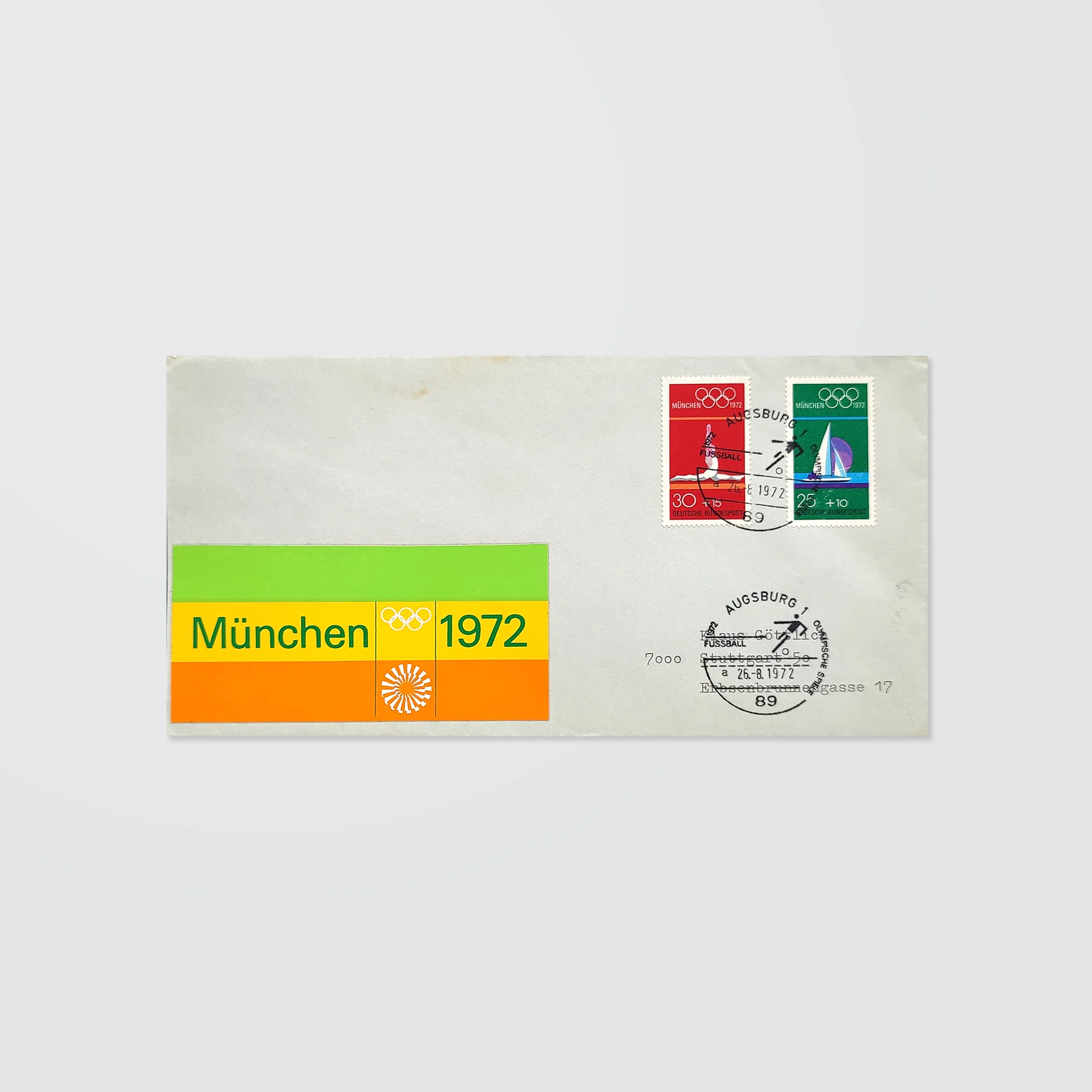 A stamped envelope with special postmarks and a colourful striped logo sticker for the Munich 1972 Olympics