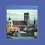 Thumbnail: Cityscape of Munich with historic domed and spired buildings under a cloudy sky. Mountains in distance. Text: "In the centre