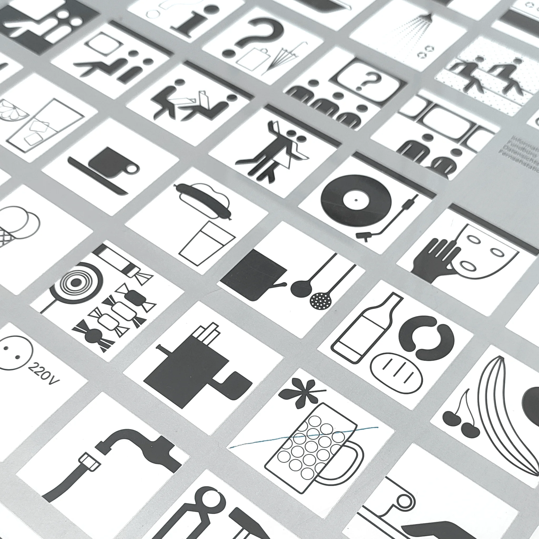Grid of black-and-white icon tiles showing people, objects, music, food, and tools on a clean white background