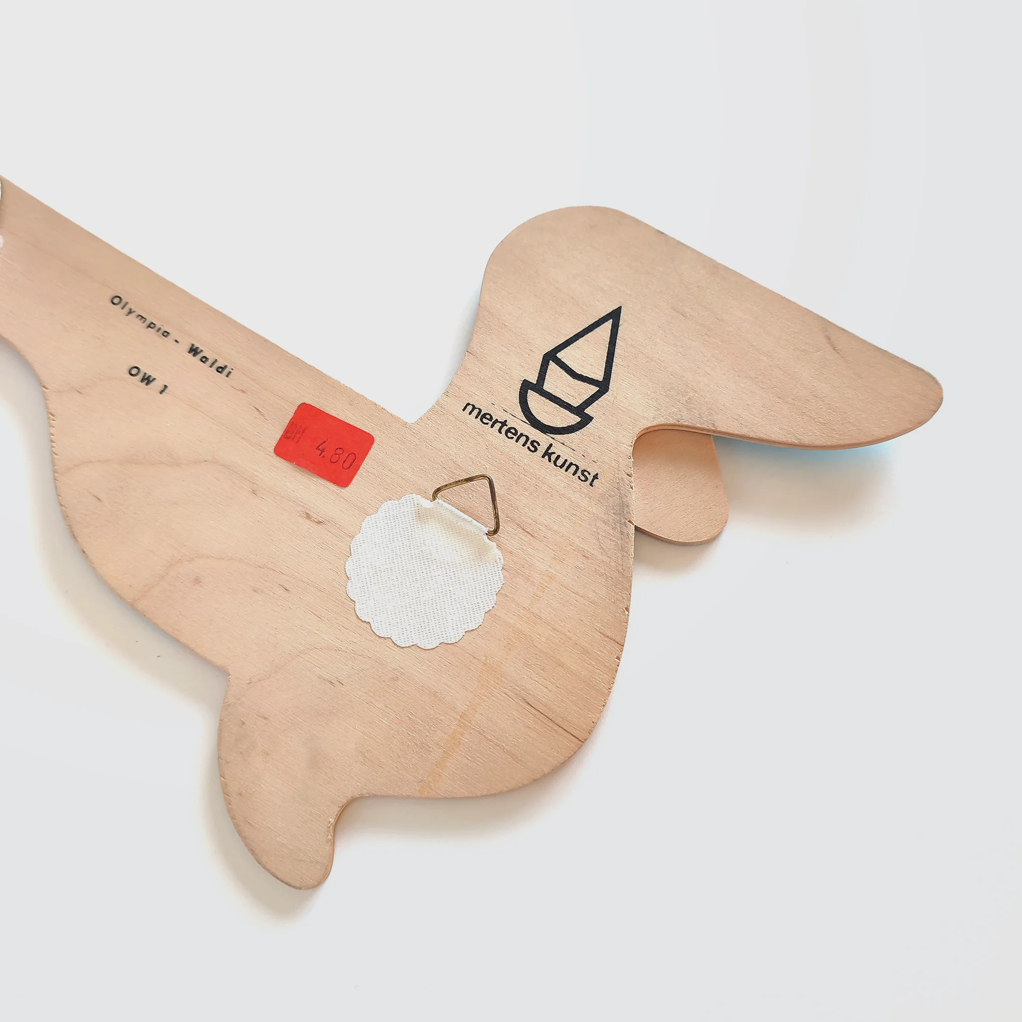 Detail of a plywood wall figure version of Olympia Waldi showing the makers name: Mertens Kunst