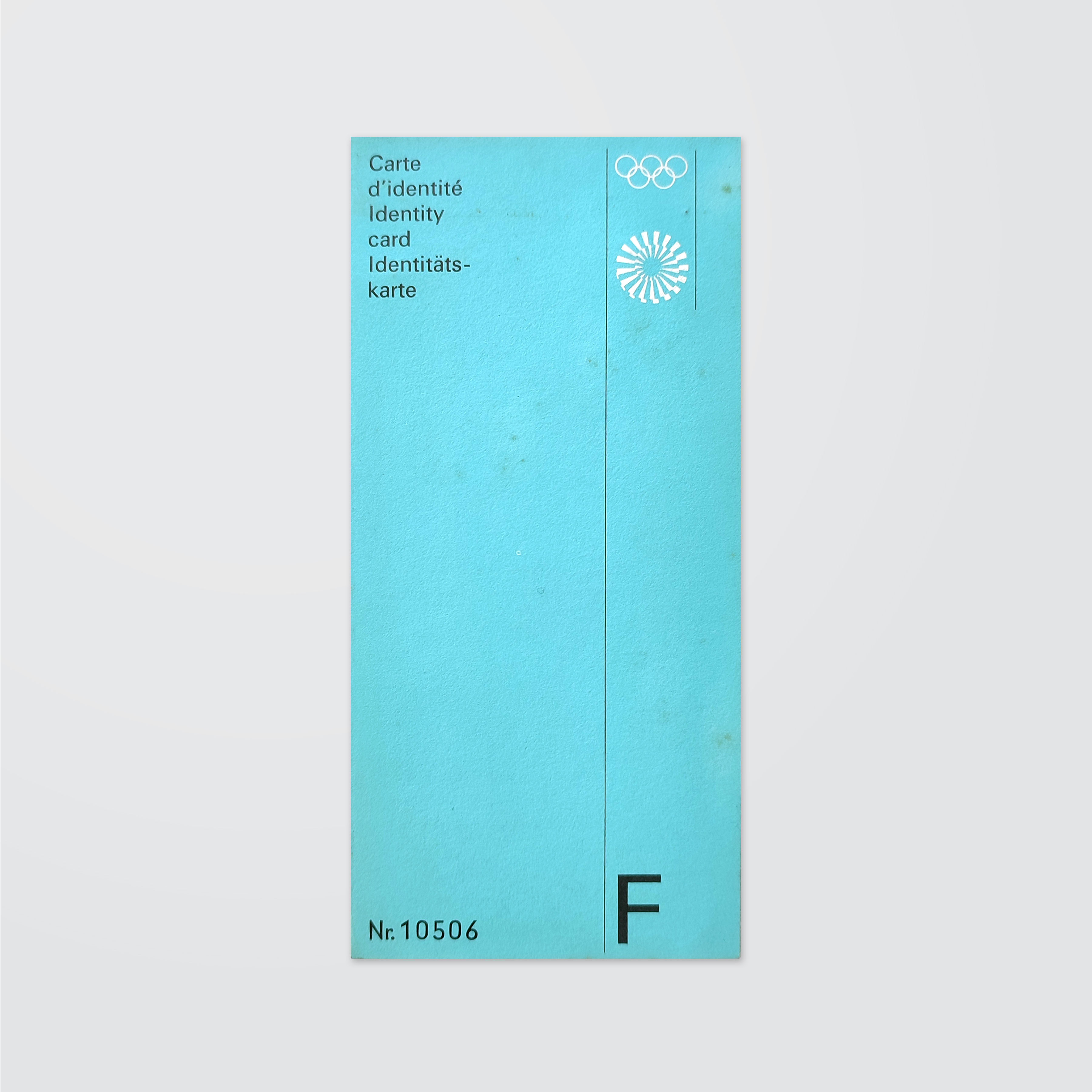 Light blue identity card booklet with multilingual text, Olympic rings, Munich 1972 spiral logo, Nr. 10506, and a large F
