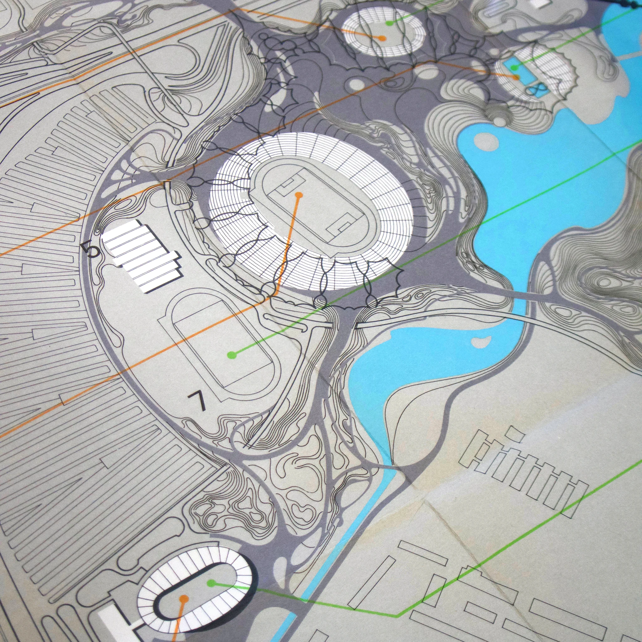 Architectural site plan with circular structures, waterways and paths. Blue and grey tones with numbered areas and lines.