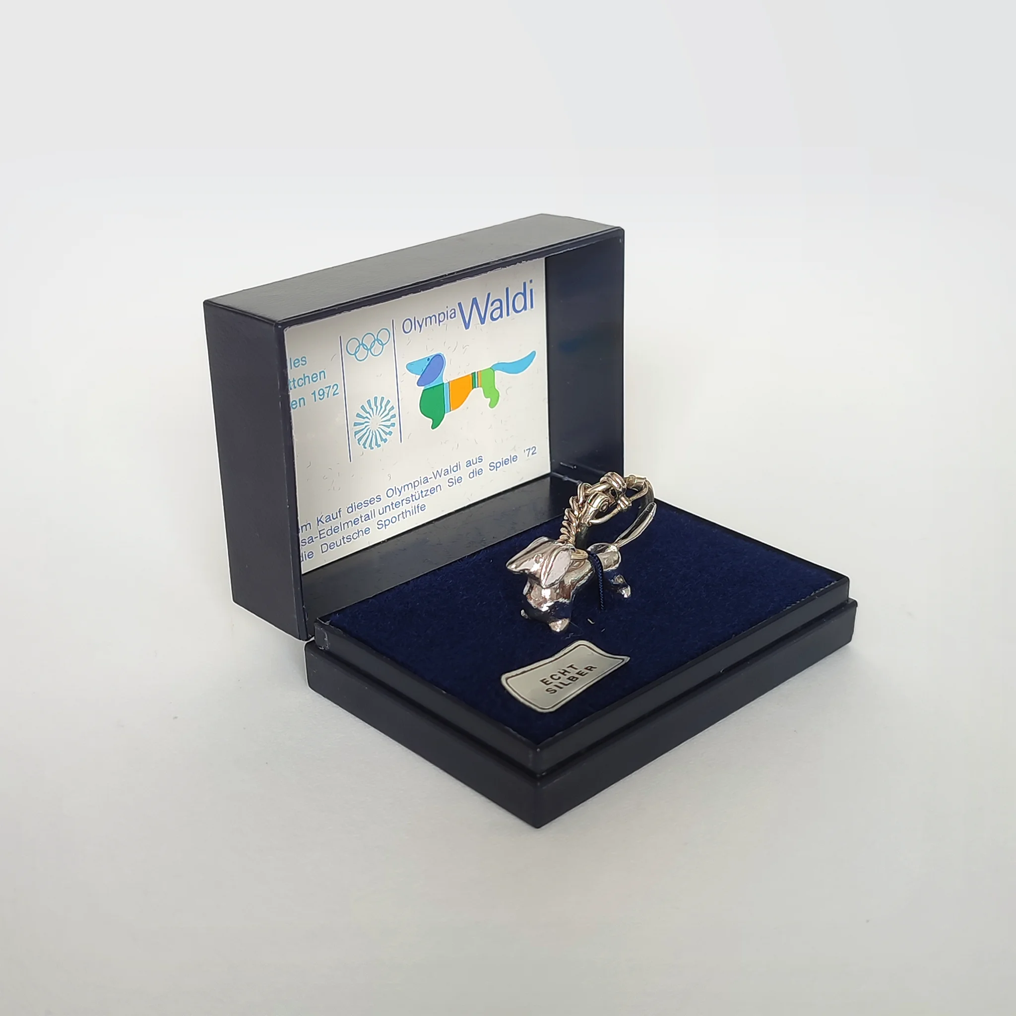 A silver keyring version of Olympia Waldi in a presentation jewellery box
