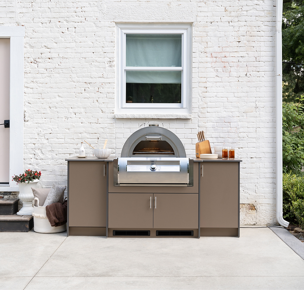 Modern outdoor kitchen setup featuring Agora Outdoor Cabinets with built-in stainless steel pizza oven, shown against a white brick home exterior.