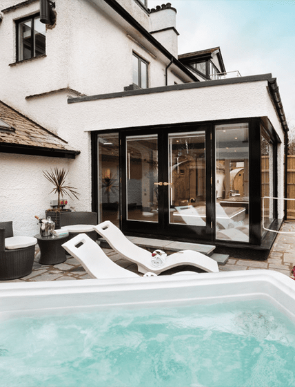 Best in Backyards' South Seas Series - 737LE Hot Tub outside of a screened in porch.