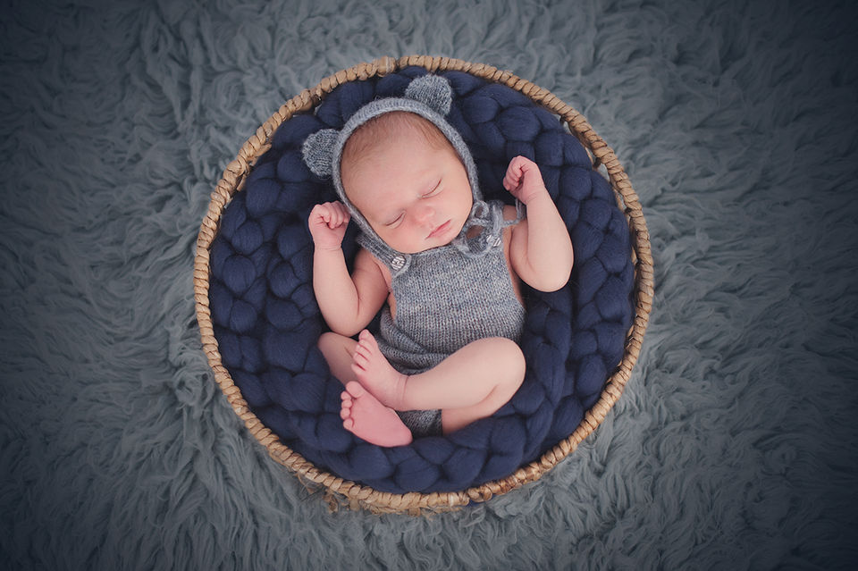 A baby wearing a cute hat with ears and matching knitted baby grow